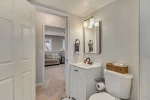 Bathroom with vanity, a textured ceiling, and toilet