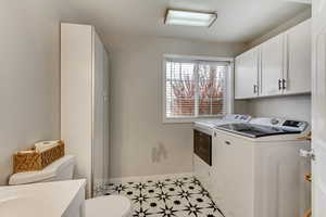 Laundry room featuring cabinets and washer and clothes dryer