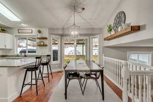 Dining space featuring lofted ceiling, an inviting chandelier, and light wood-type flooring