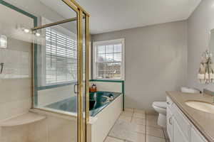 Full bathroom featuring tile patterned floors, toilet, vanity, and shower with separate bathtub