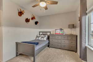 Carpeted bedroom featuring ceiling fan