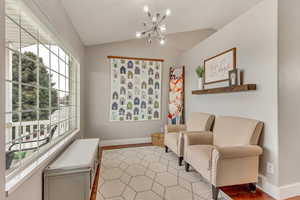 Living area featuring a notable chandelier and vaulted ceiling