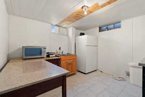 Kitchen with wooden ceiling, sink, and white fridge