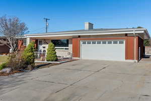 Single story home featuring covered porch and a garage