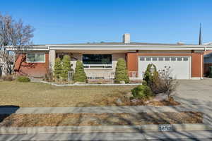 Ranch-style home with a front lawn and a garage