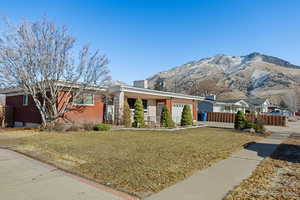 View of front facade with a front yard, a mountain view, and a garage