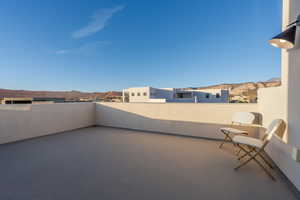 View of patio with a balcony and a mountain view