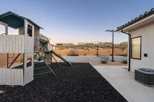 Playground at dusk with cooling unit, tennis court, and basketball hoop