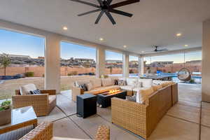 View of patio with a fenced in pool, an outdoor living space with a fire pit, pool water feature, and ceiling fan