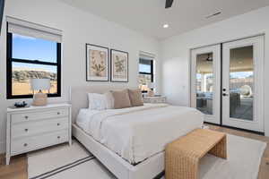 Bedroom with multiple windows, access to exterior, light hardwood / wood-style floors, and ceiling fan