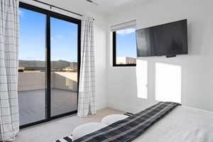 Carpeted bedroom featuring multiple windows