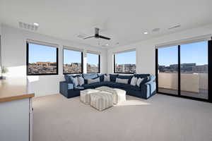 Carpeted living room featuring ceiling fan