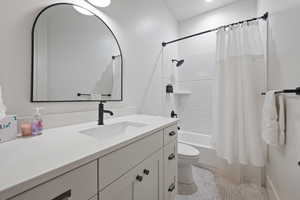 Full bathroom featuring vanity, toilet, tile patterned flooring, and shower / tub combo