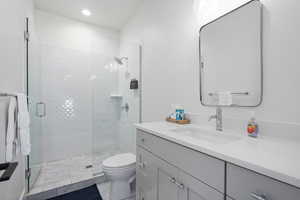 Bathroom featuring vanity, tile patterned flooring, toilet, and walk in shower