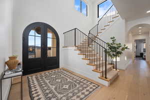 Foyer featuring light hardwood / wood-style floors, french doors, and a high ceiling