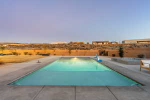 Pool at dusk with an in ground hot tub