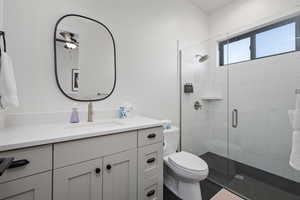 Bathroom featuring vanity, toilet, and an enclosed shower