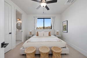 Carpeted bedroom with ceiling fan and ensuite bath