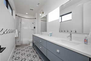 Full bathroom featuring tile patterned floors, vanity, toilet, and shower / tub combo