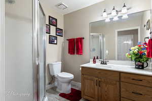 Bathroom featuring vanity, toilet, and walk in shower