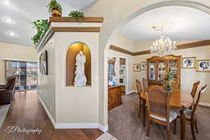 Dining room with vaulted ceiling, dark wood-type flooring, and a chandelier