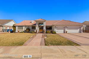 Mediterranean / spanish-style house featuring a garage and a front lawn