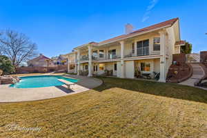 View of swimming pool featuring a patio, a diving board, a yard, and pool water feature