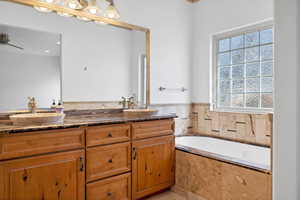 Bathroom with vanity and tiled bath