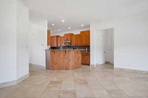 Kitchen with decorative backsplash, a kitchen breakfast bar, and a center island