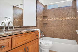 Full bathroom featuring vanity, toilet, and tiled shower / bath