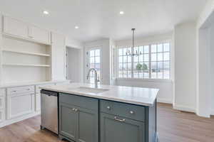 Kitchen featuring gray cabinets, a sink, stainless steel dishwasher, light wood-style floors, and white cabinets