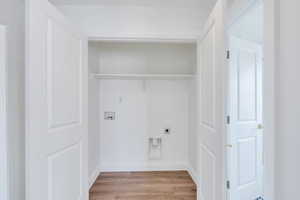 Washroom featuring light wood finished floors, baseboards, laundry area, hookup for a washing machine, and hookup for an electric dryer