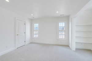 Spare room featuring recessed lighting, baseboards, visible vents, and light carpet
