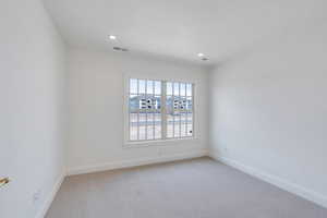 Unfurnished room with recessed lighting, baseboards, and light carpet