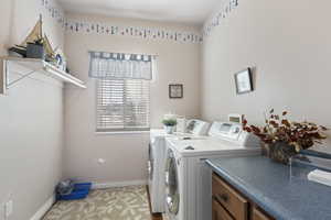 Laundry room with cabinets and washer and clothes dryer