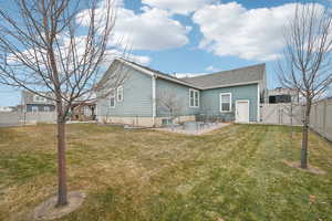 Rear view of property with a yard and a patio area