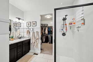 Bathroom with tile patterned flooring, vanity, and walk in shower