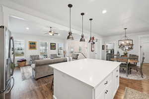 Kitchen featuring pendant lighting, white cabinetry, a center island, stainless steel refrigerator with ice dispenser, and dark hardwood / wood-style flooring