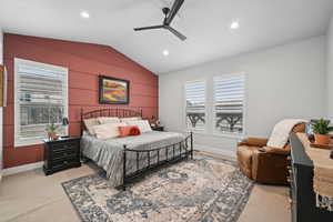 Carpeted bedroom with ceiling fan and vaulted ceiling