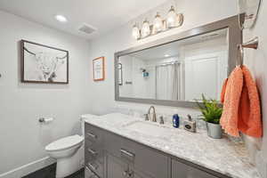 Bathroom featuring tile patterned flooring, vanity, toilet, and a shower with curtain