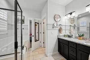 Bathroom featuring an enclosed shower, vanity, and tile patterned floors