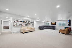 Carpeted living room with built in shelves