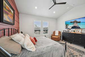 Carpeted bedroom with vaulted ceiling and ceiling fan