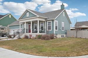 View of front facade with a porch, a garage, and a front yard