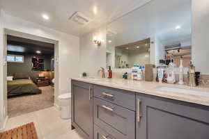 Bathroom featuring tile patterned flooring, vanity, a shower with door, and toilet