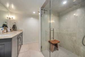 Bathroom featuring vanity, tile patterned flooring, walk in shower and heated flooring