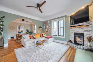 Living room with hardwood / wood-style flooring, a fireplace, and ceiling fan