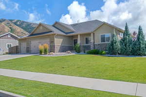 View of front of home featuring a garage, a mountain view, and a front lawn