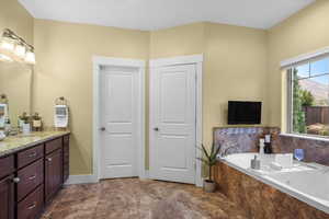 Bathroom featuring vanity and tiled tub