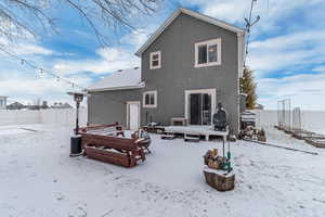 Snow covered house featuring an outdoor fire pit